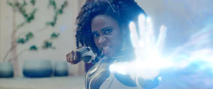 HD wallpaper of a powerful female superhero from The Marvels, ready for action with a determined expression and energy emanating from her hand.