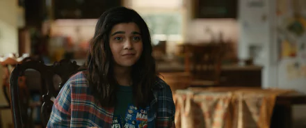 Iman Vellani in a scene from the movie The Marvels, dressed casually with a plaid shirt, captures a moment of warmth and charm in this HD desktop wallpaper.