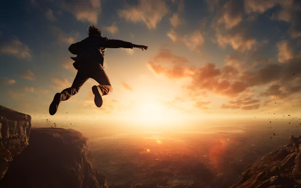 HD desktop wallpaper of a person jumping off a cliff at sunset, set against a dramatic sky and sweeping landscape.