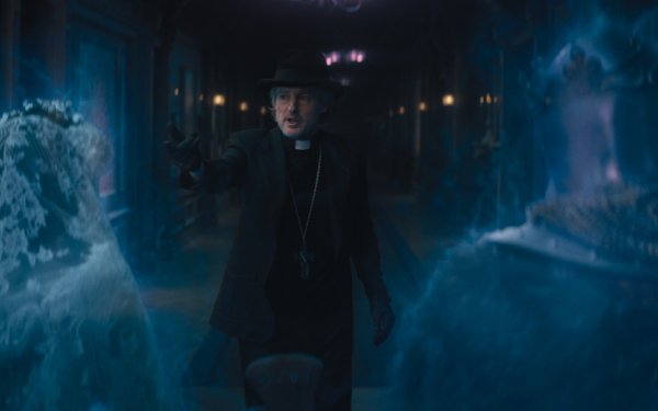 HD wallpaper featuring a scene from Haunted Mansion with a character dressed as a priest confronting a ghostly apparition in a dimly lit corridor, encapsulating a spooky and mysterious atmosphere.