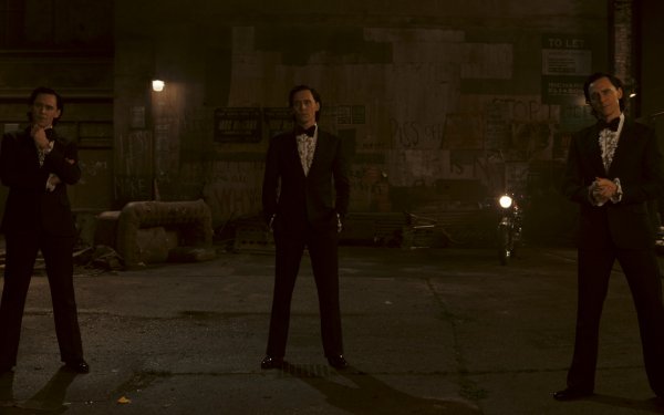 Three men in suits standing in a dimly lit alleyway from the Loki Season 2 series - a high-definition desktop wallpaper.