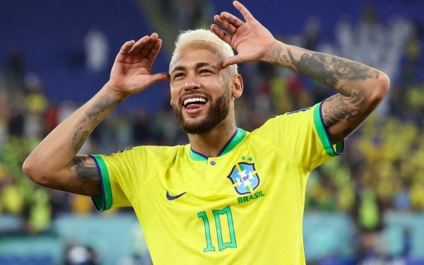 HD wallpaper of a cheerful soccer player in Brazil National Football Team jersey number 10, hands to ears in a playful gesture, on the field.