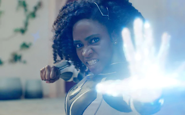 HD wallpaper of a powerful female superhero from The Marvels, ready for action with a determined expression and energy emanating from her hand.