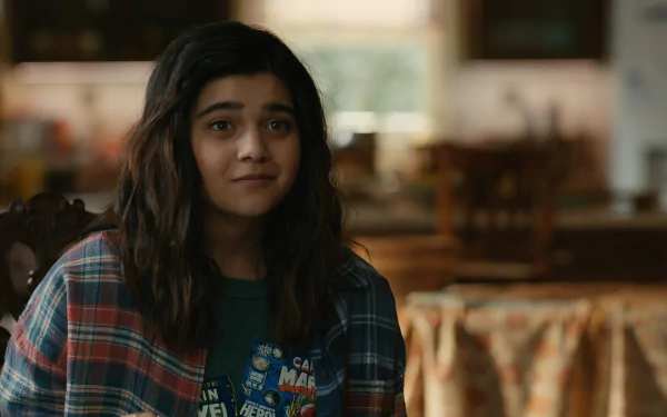 Iman Vellani in a scene from the movie The Marvels, dressed casually with a plaid shirt, captures a moment of warmth and charm in this HD desktop wallpaper.