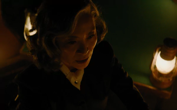 A haunting moment from the movie A Haunting in Venice, featuring a woman illuminated by warm lantern light, creating an eerie and suspenseful atmosphere. HD wallpaper for movie fans.