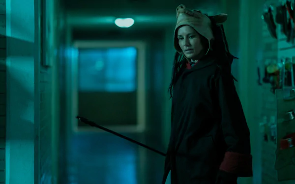 Mysterious figure in a dimly lit corridor with a crown-like headpiece, evoking a scene from Saw X, as an HD desktop wallpaper and background.