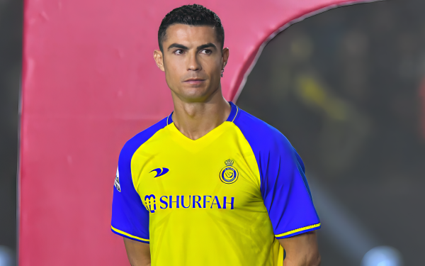 HD desktop wallpaper featuring a soccer player in a yellow and blue kit, standing confidently with a focused expression.