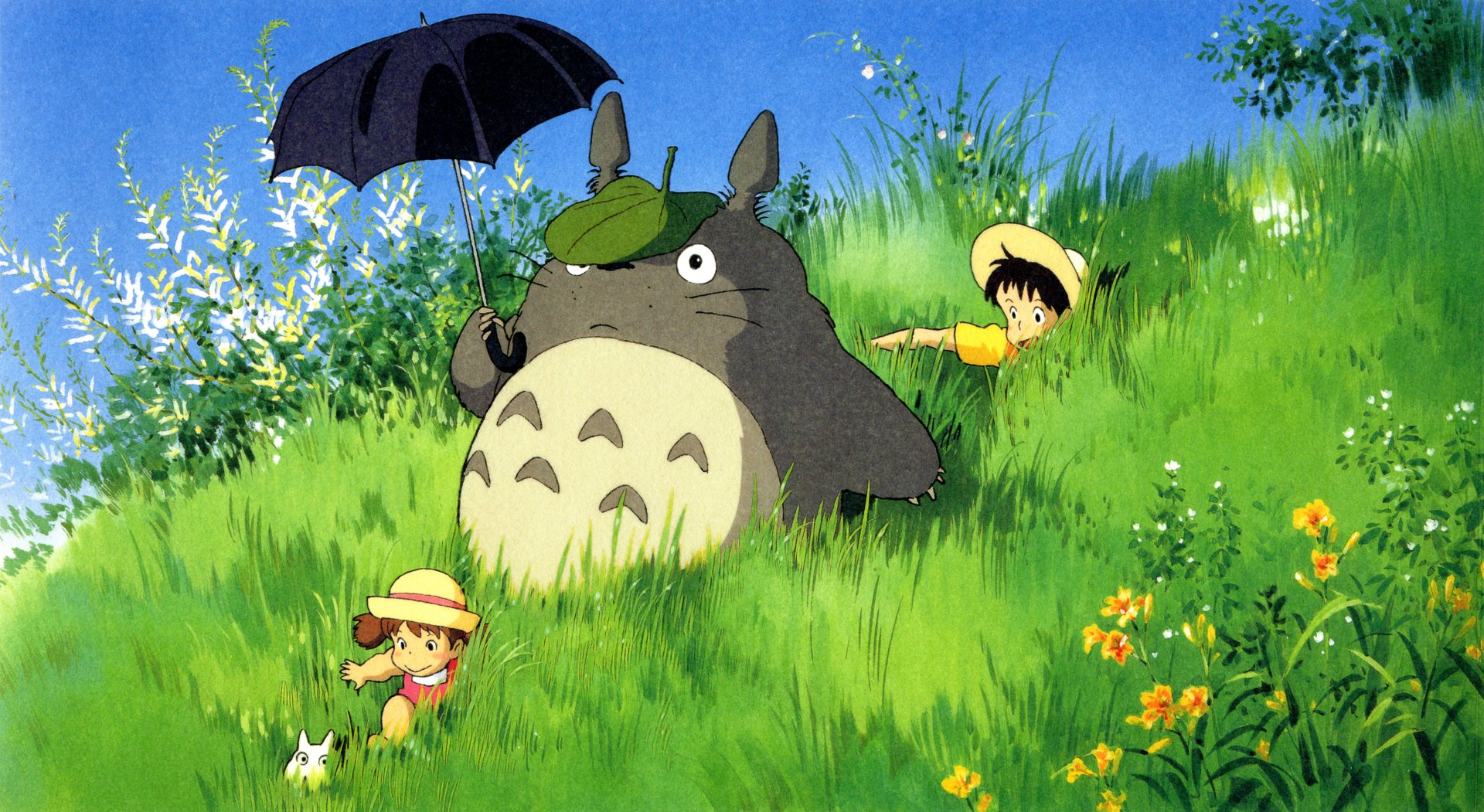 A vibrant HD wallpaper featuring Totoro, the beloved character from Studio Ghibli's My Neighbor Totoro, alongside two children enjoying a sunny day in a grassy field.