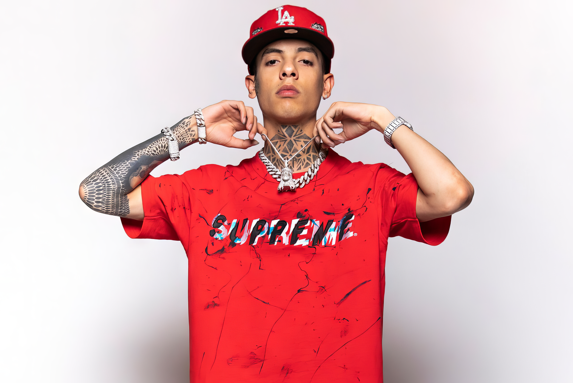 HD wallpaper of a young man in a red Supreme shirt with trendy jewelry, posing confidently as a stylish desktop background.