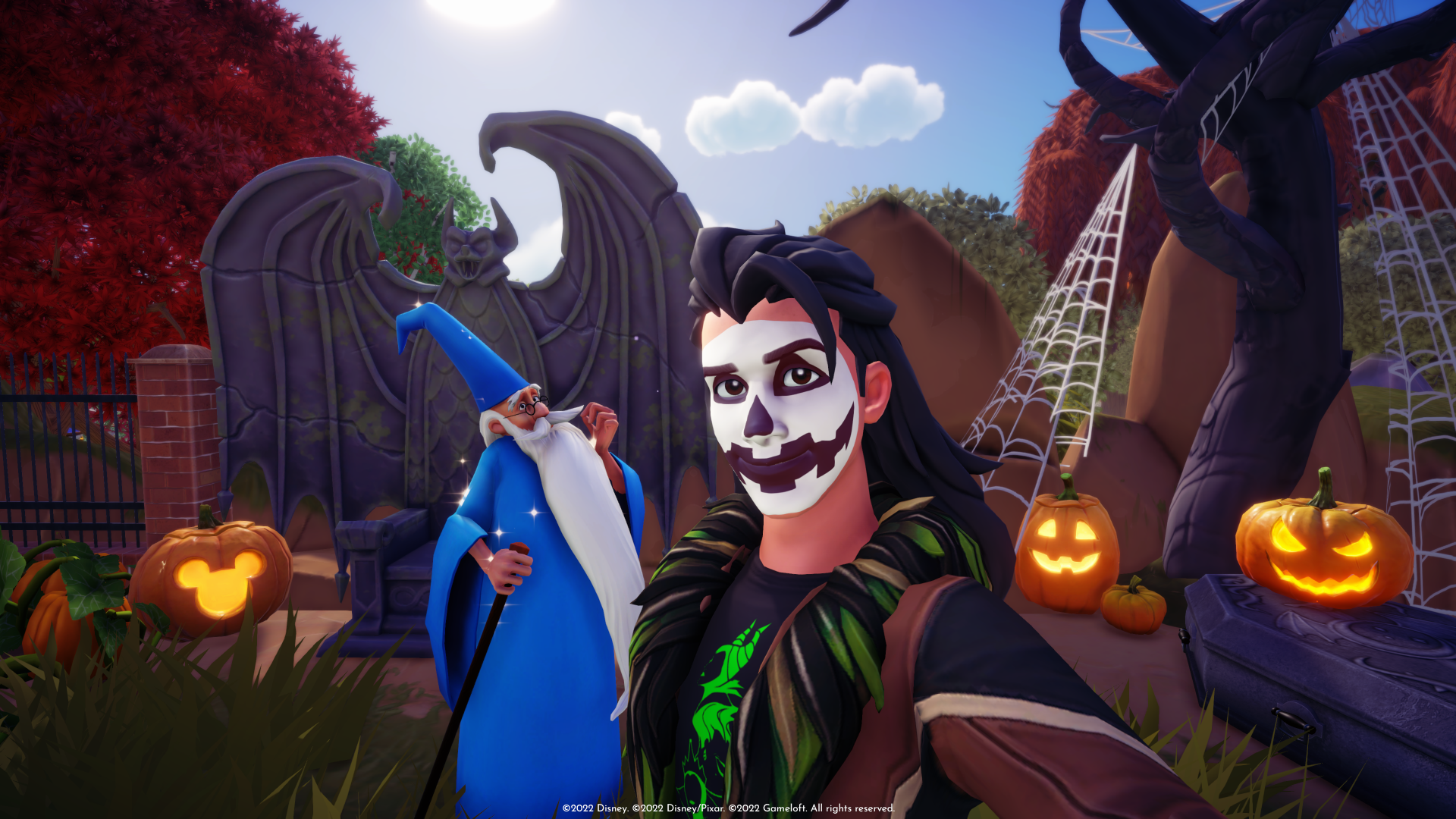 HD Disney Dreamlight Valley desktop wallpaper featuring a character with face paint alongside the wizard Merlin, set in a magical world with pumpkins and whimsical decorations.