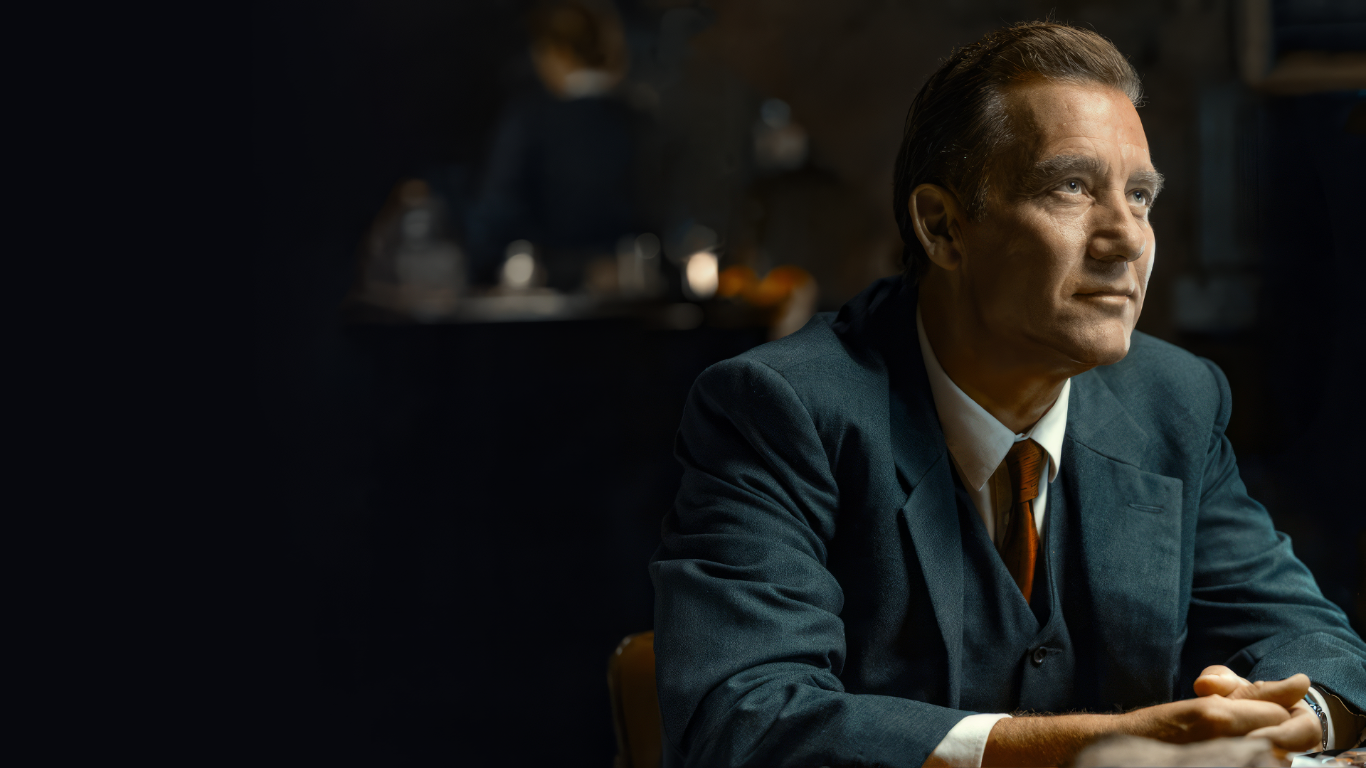 HD wallpaper of a man in a blue suit portraying a character in a dimly lit setting, suggestive of a scene from the TV show Monsieur Spade.