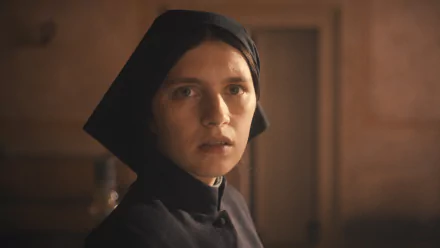 HD desktop wallpaper featuring a character dressed as a nun from 'The First Omen' movie with a contemplative expression, set against a subtle indoor background.