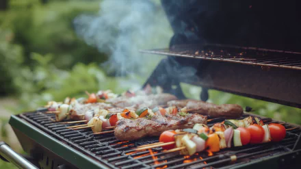 HD desktop wallpaper featuring skewers and steaks on a smoking BBQ grill for a delicious outdoor cooking background.