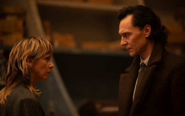 HD wallpaper featuring two characters in a deep conversation, evoking the ambiance of the Loki series, with the male character resembling actor Tom Hiddleston and the female character resembling actress Sophia Di Martino.