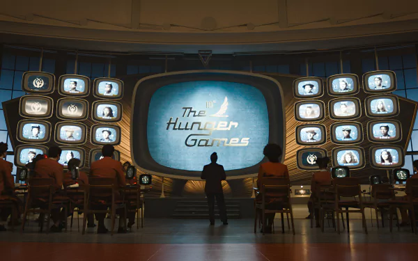 HD desktop wallpaper featuring a scene from 'The Hunger Games: The Ballad of Songbirds & Snakes' with silhouettes of viewers in front of a large screen displaying the movie title.