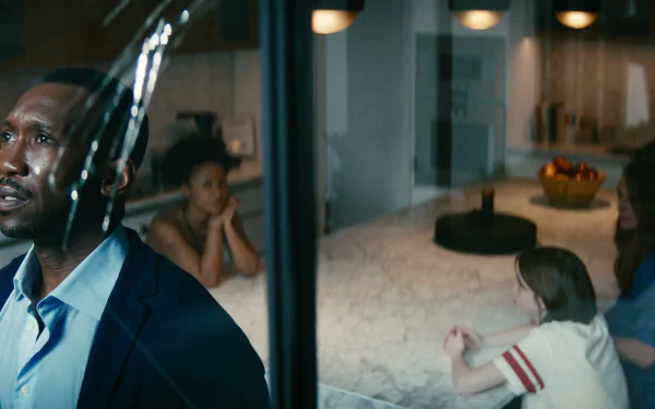 HD wallpaper featuring a scene from the movie Leave the World Behind with a man in the foreground and family members in a home interior in the background.