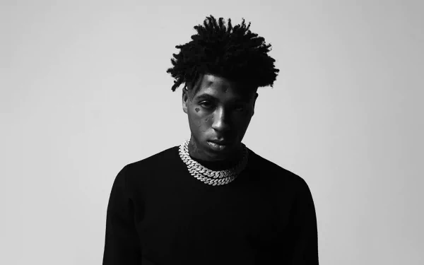 Monochrome HD wallpaper featuring a young rapper in a black sweater and chain, embodying the music theme.