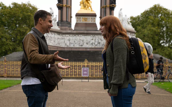 HD wallpaper of two characters from the movie Argylle conversing in front of an ornate monument.