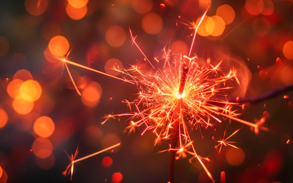 A vibrant sparkler ignites with radiant light, surrounded by warm, blurred bokeh. This HD desktop wallpaper adds a festive touch to any background.