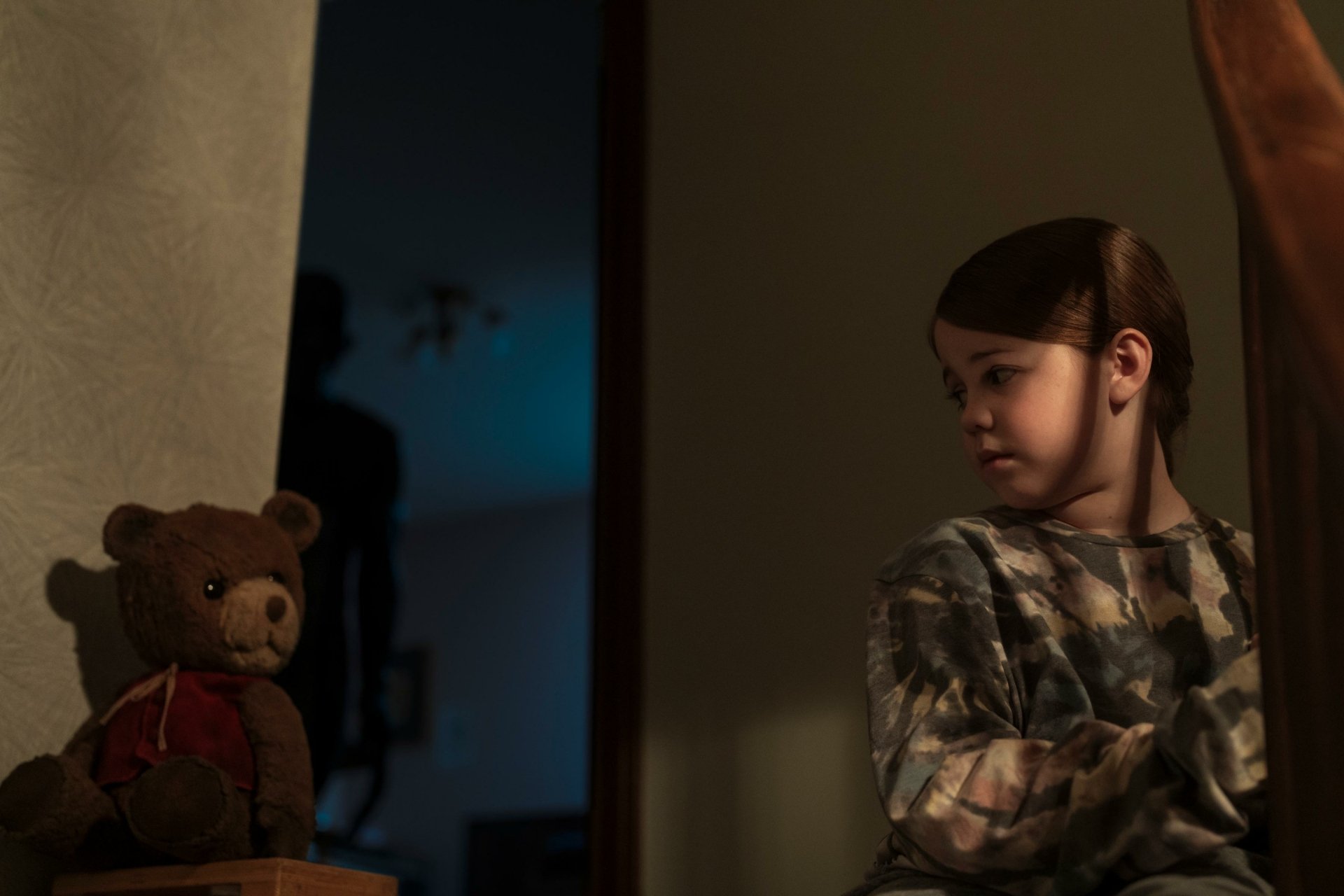 HD wallpaper of a scene from 'Imaginary' (2024) movie featuring a child and teddy bear with a mysterious shadow in the background.