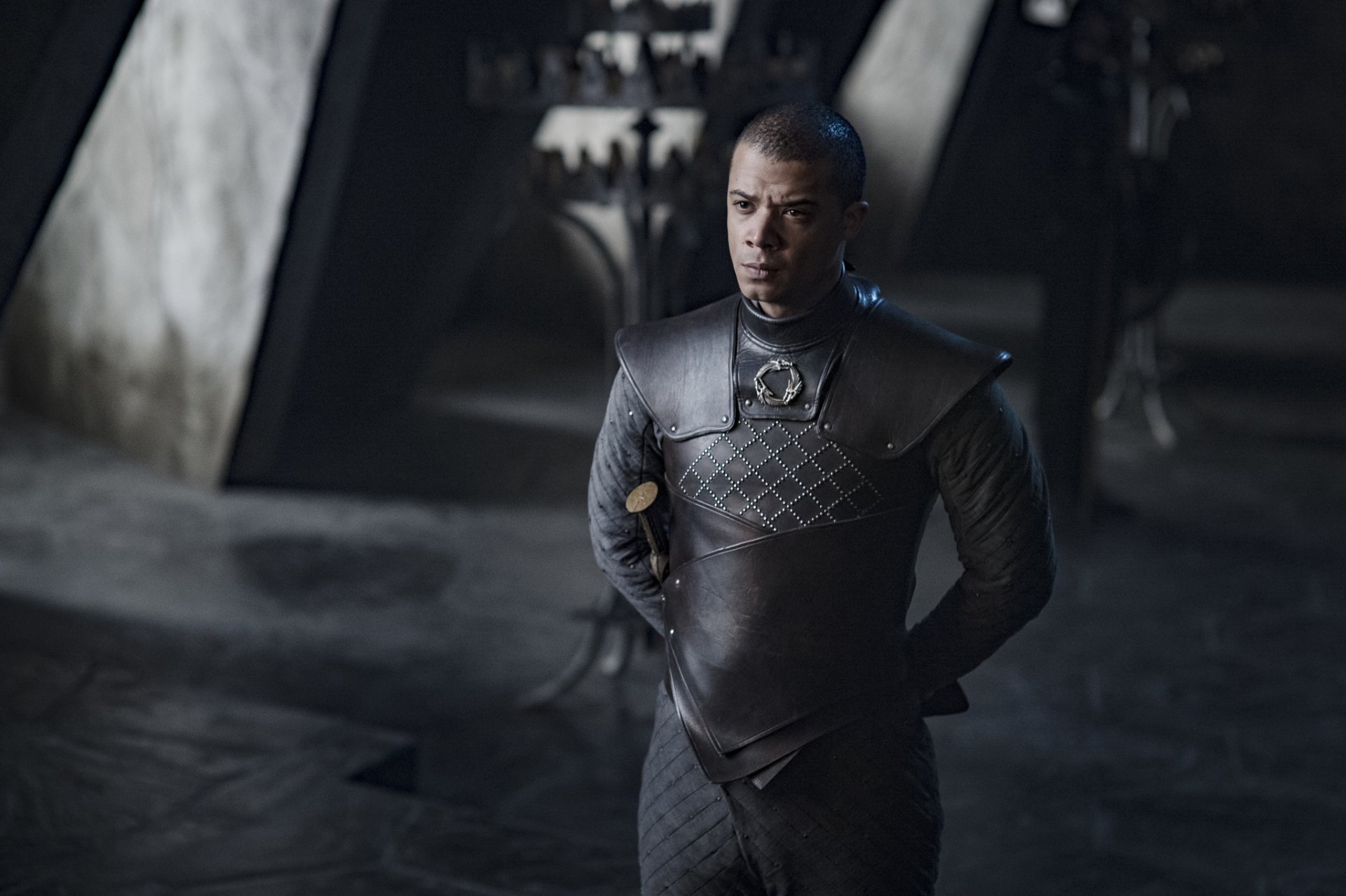 HD wallpaper of a Game of Thrones character dressed in armor standing solemnly in a dimly lit medieval setting.