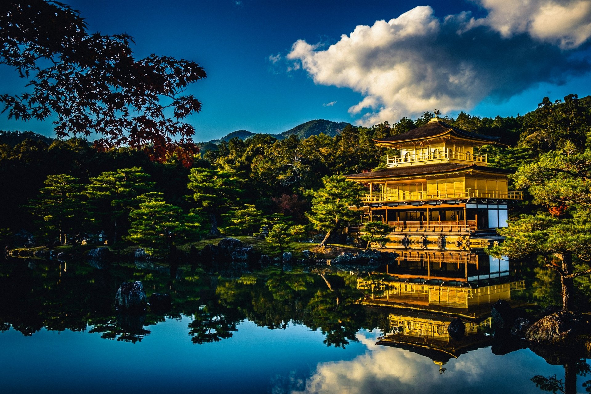 Stunning HD wallpaper featuring the iconic Kinkaku-ji Temple and its reflection on a serene lake in Kyoto, Japan, surrounded by lush greenery.