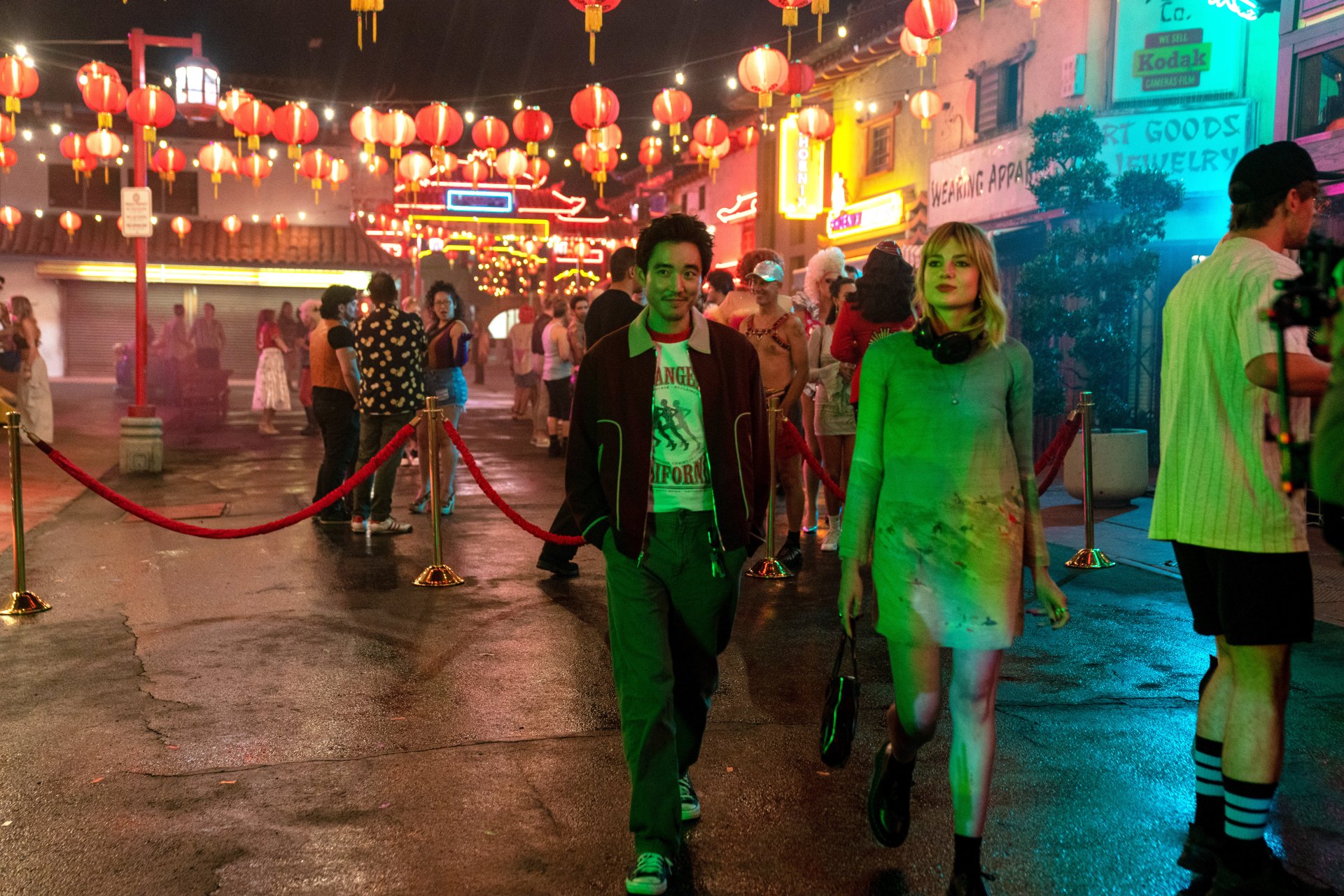 HD wallpaper with a vibrant night scene from the movie The Greatest Hits featuring actors in character walking through a lively street adorned with Chinese lanterns.