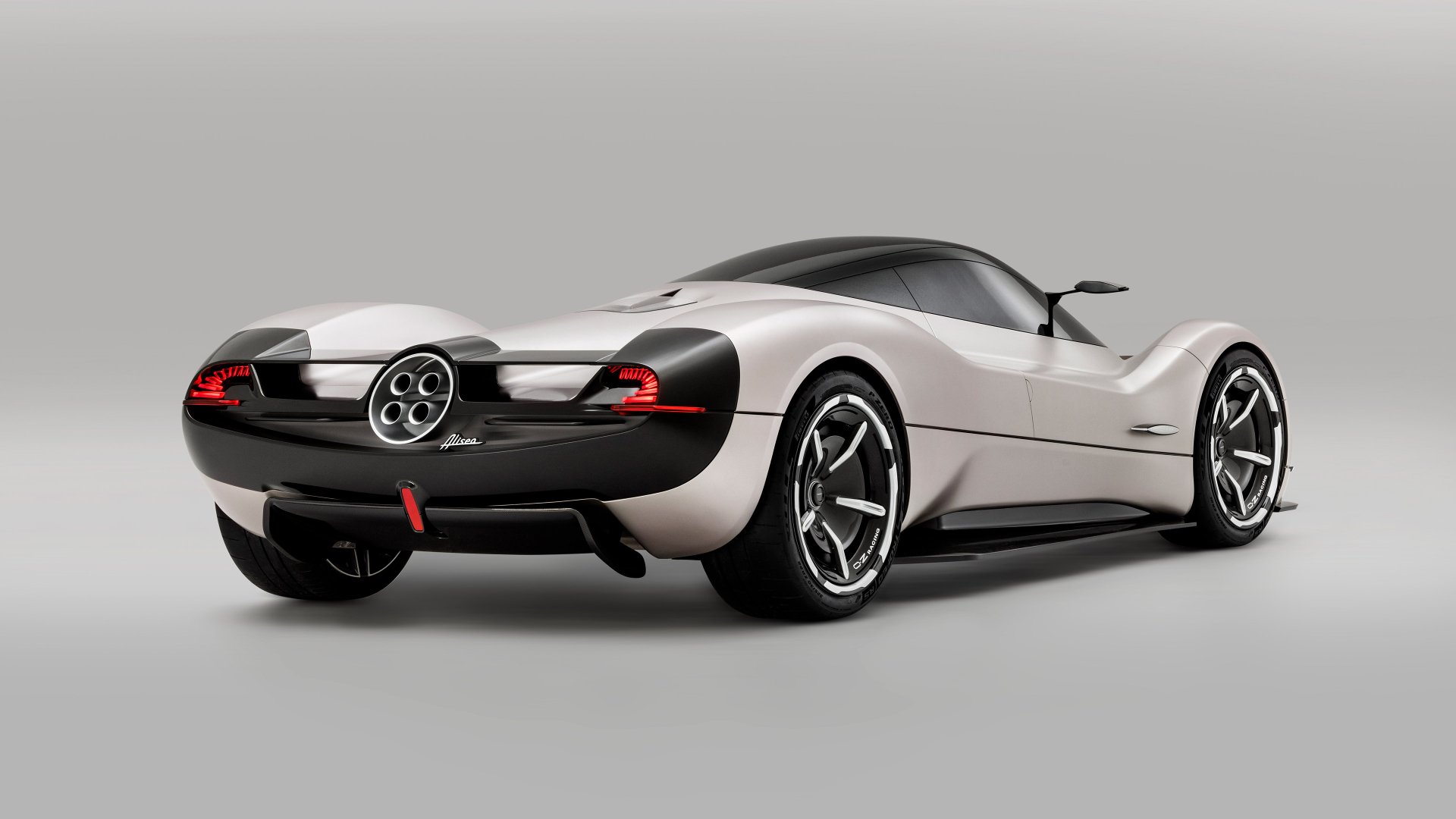HD desktop wallpaper featuring a rear three-quarter view of a silver Pagani Huayra, highlighting its sleek design and distinctive circular taillights against a clean, neutral background.