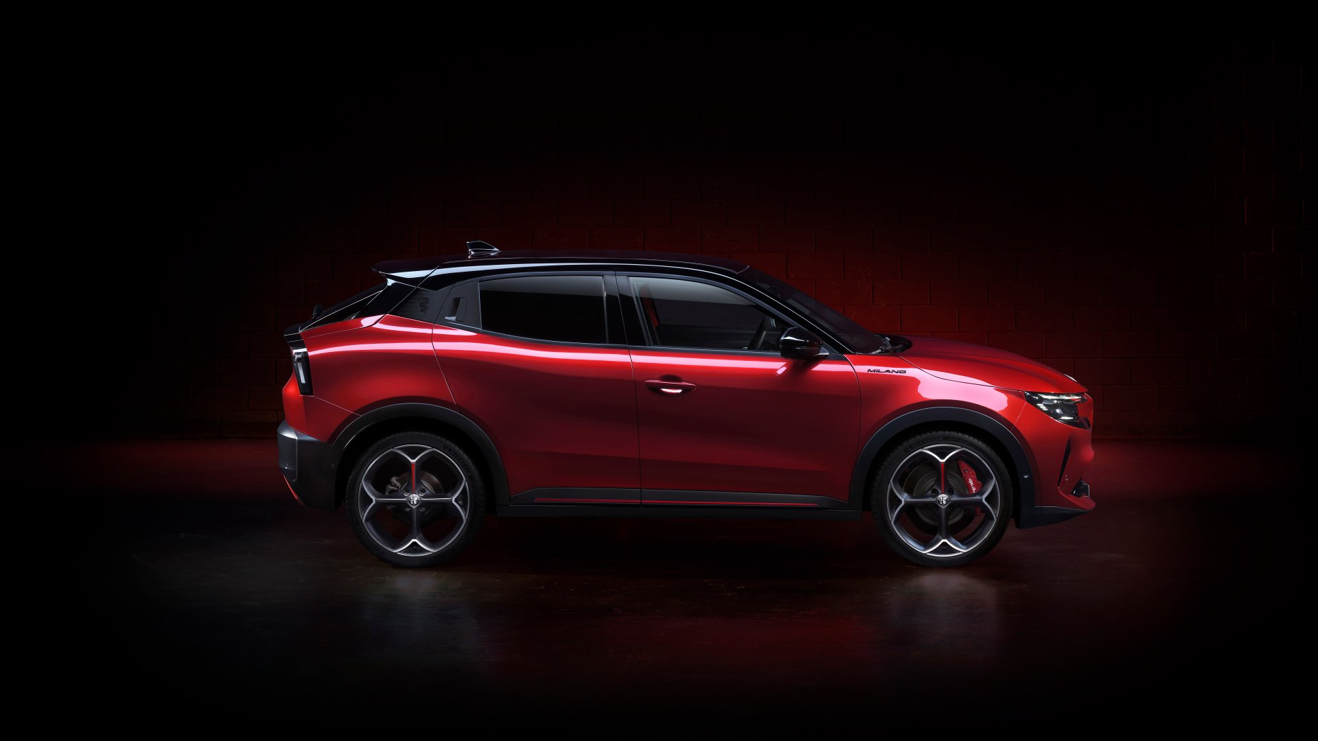 Alfa Romeo Milano Veloce parked against a dark background, showcased as a sleek red HD desktop wallpaper.