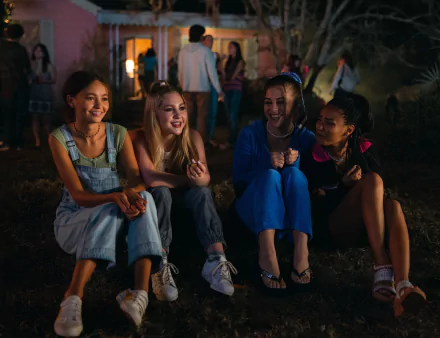HD wallpaper of a scene from the movie Suncoast (2024), featuring four young women enjoying an evening outdoors.