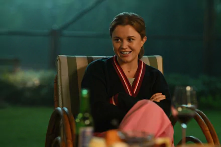 HD desktop wallpaper featuring a scene from the TV show Apples Never Fall with a smiling character sitting in a garden chair at nighttime.