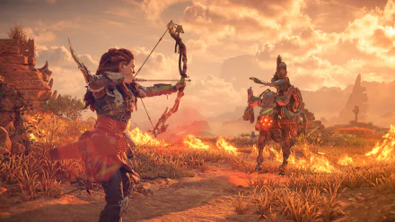 Desktop wallpaper featuring Aloy with a bow in Horizon Forbidden West game set against a fiery sunset backdrop.