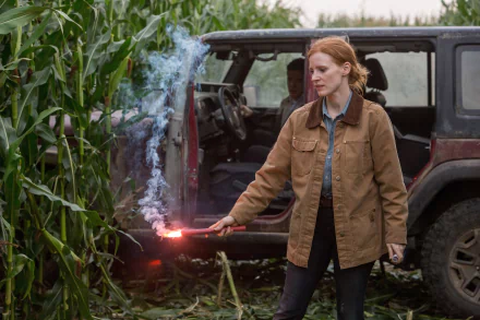 HD Wallpaper of a scene from the movie Interstellar featuring the character next to a vehicle with a flare, amidst cornfields.