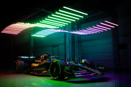 HD wallpaper of a Mercedes-AMG F1 W14 race car under vibrant neon lights.