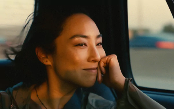 HD desktop wallpaper and background featuring a pensive woman from the movie Past Lives, gazing out a car window.