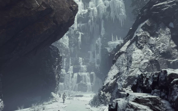 An atmospheric HD wallpaper from Banishers: Ghosts of New Eden, featuring a figure walking through a snowy canyon with towering ice formations and rugged, dark cliffs.