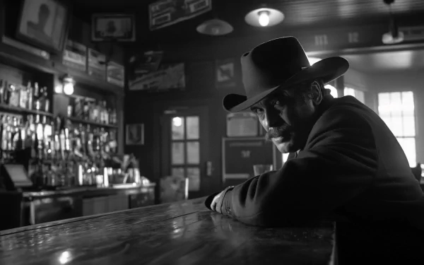 Black and white HD wallpaper featuring a contemplative sheriff seated at a saloon bar, evoking classic Western atmosphere for desktop background.