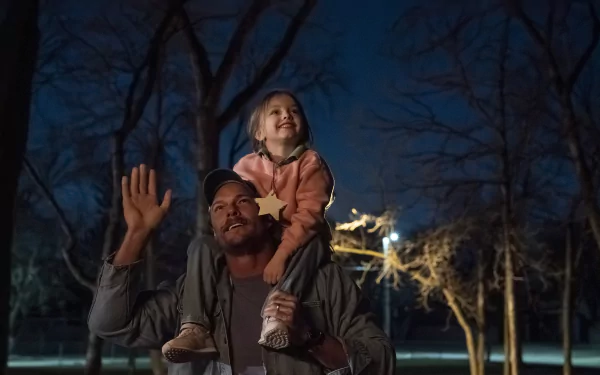 HD desktop wallpaper depicting a heartwarming scene from the movie Ordinary Angels with a man holding a joyful child on his shoulders at dusk.