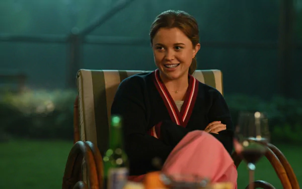 HD desktop wallpaper featuring a scene from the TV show Apples Never Fall with a smiling character sitting in a garden chair at nighttime.