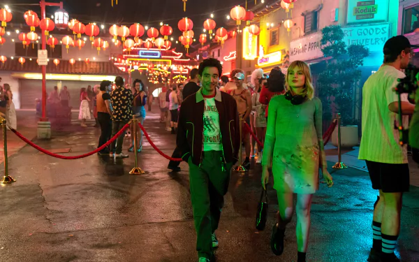 HD wallpaper with a vibrant night scene from the movie The Greatest Hits featuring actors in character walking through a lively street adorned with Chinese lanterns.