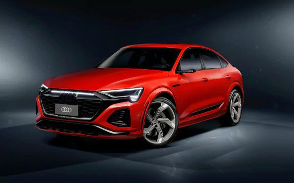 Red Audi SQ8 luxury SUV positioned prominently against a dark studio background, showcasing its design for use as a high-definition desktop wallpaper.