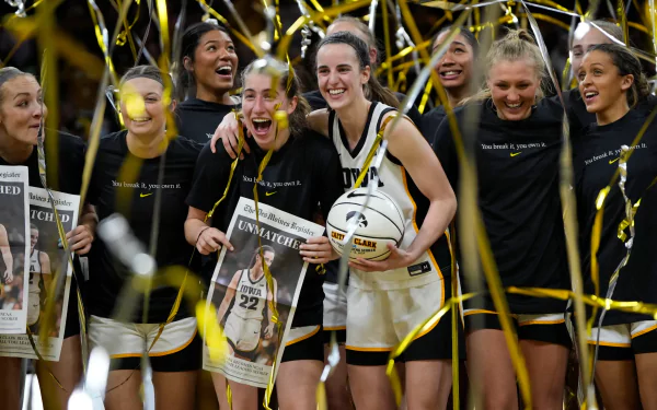 HD wallpaper of basketball player Caitlin Clark celebrating with teammates among golden confetti.