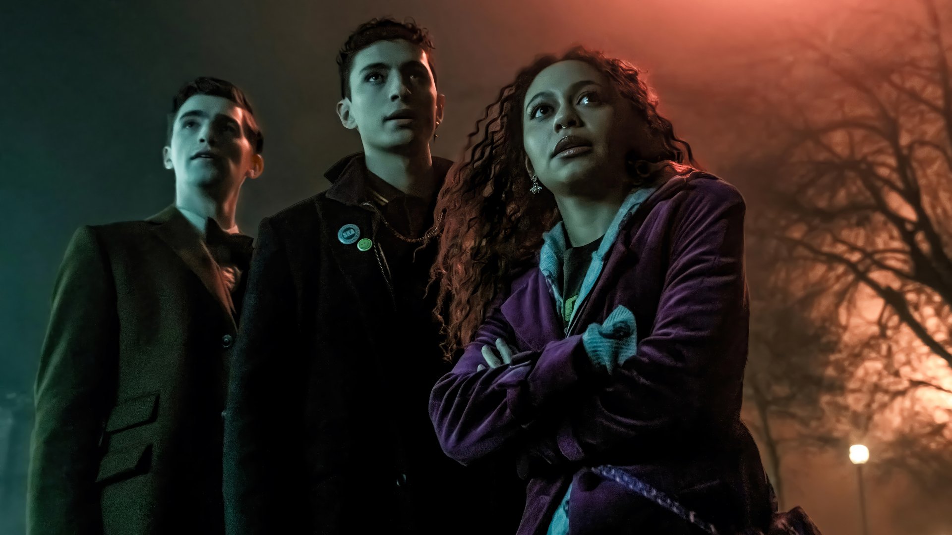 HD wallpaper featuring characters from the TV show Dead Boy Detectives standing together at night, looking upwards with serious expressions.