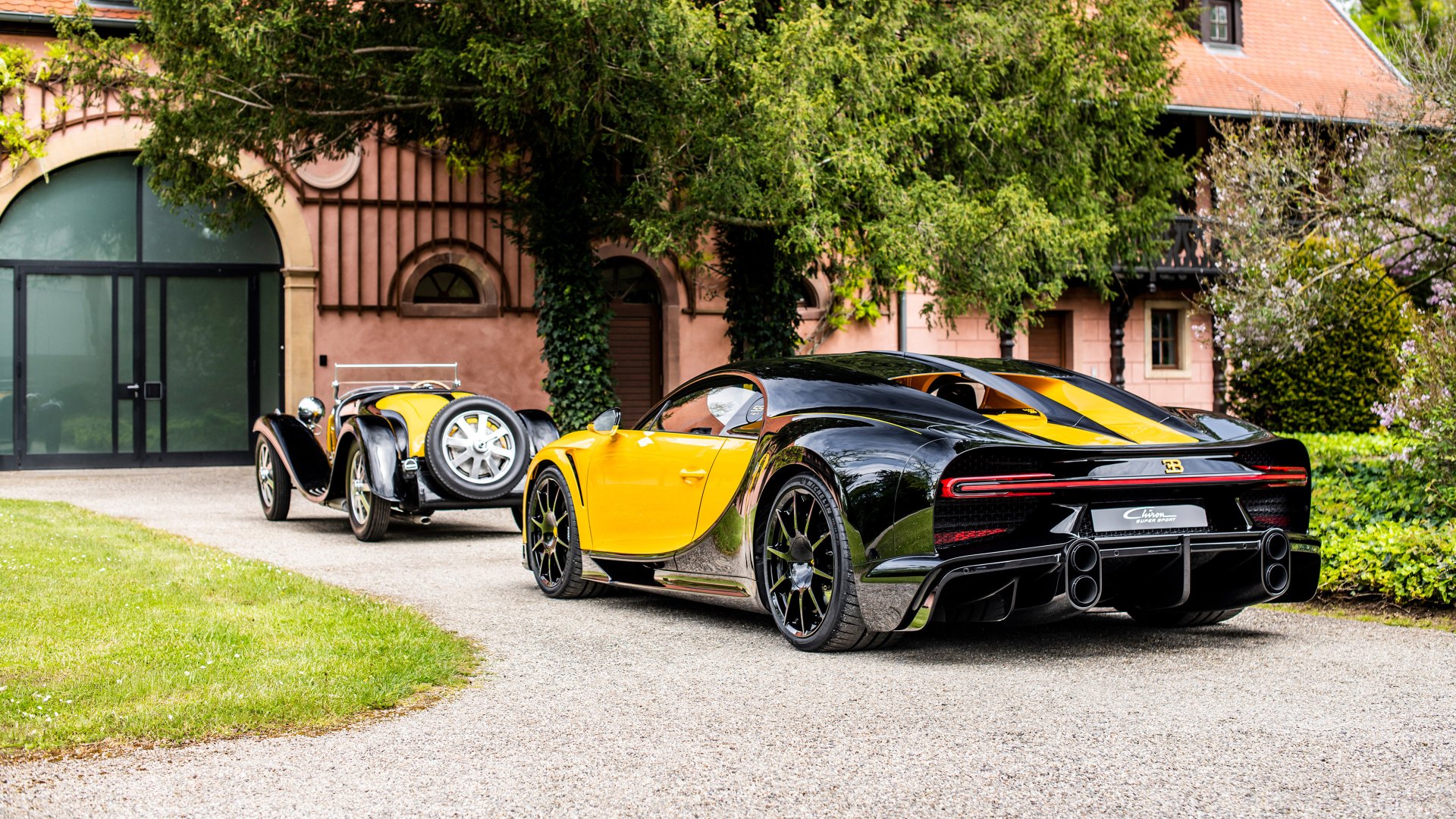 HD desktop wallpaper featuring a Bugatti Chiron Super Sport 55, in a vibrant setting with lush greenery and a classic car in the background.