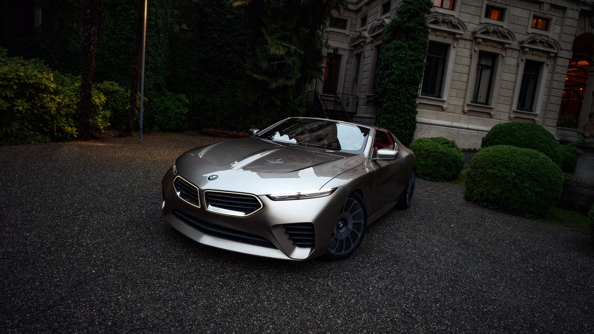 HD desktop wallpaper of a sleek BMW Skytop car, parked in a scenic setting with lush greenery and a majestic building in the background.