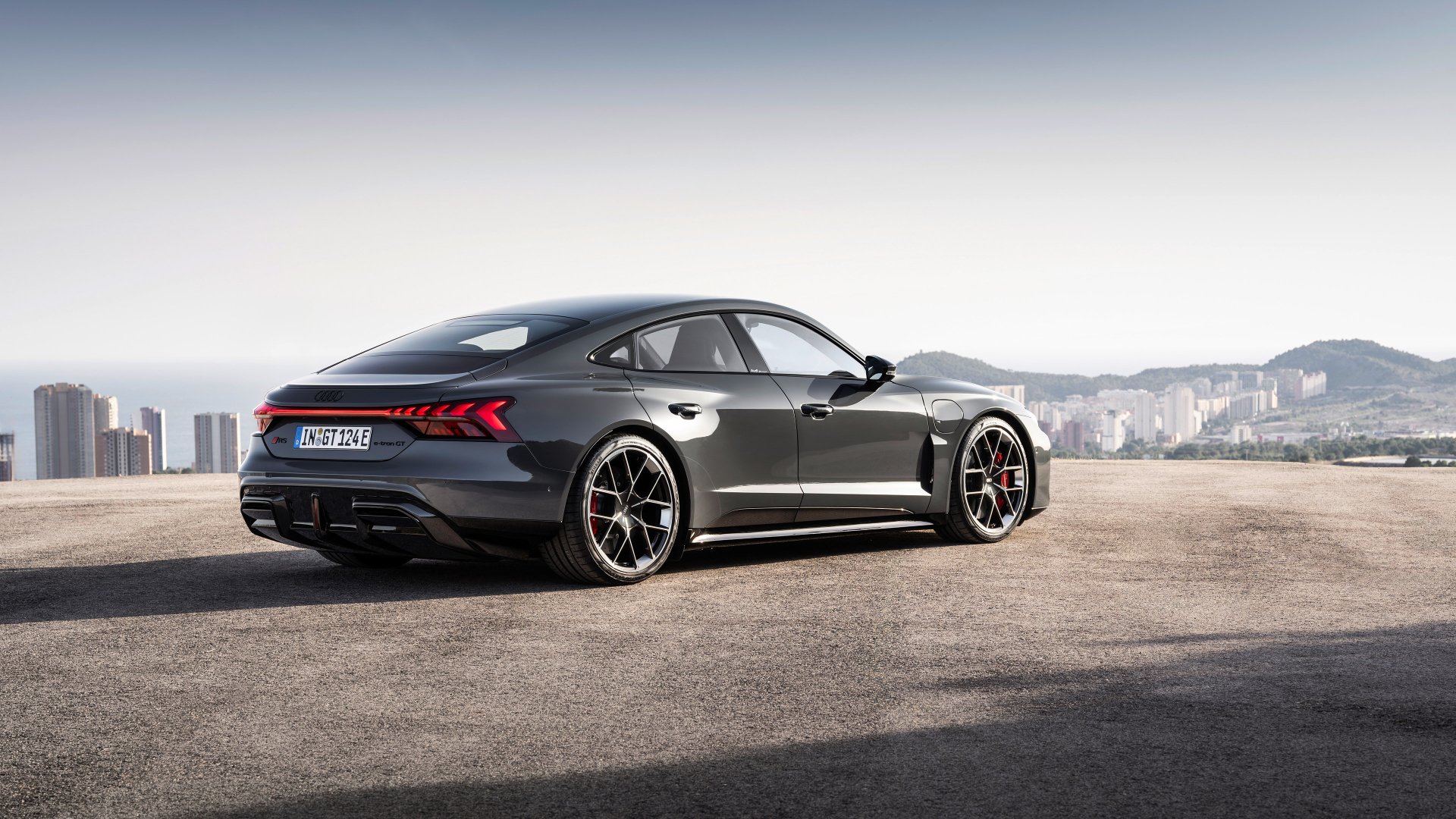 HD desktop wallpaper featuring the sleek and modern Audi RS e-Tron GT against an urban backdrop. The car's design embodies luxury and high performance.