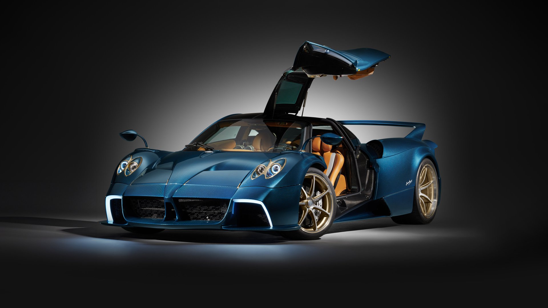 HD desktop wallpaper featuring a Pagani Huayra Epitome. The car is showcased against a dark background with its gullwing doors open, highlighting its sleek and luxurious blue design.
