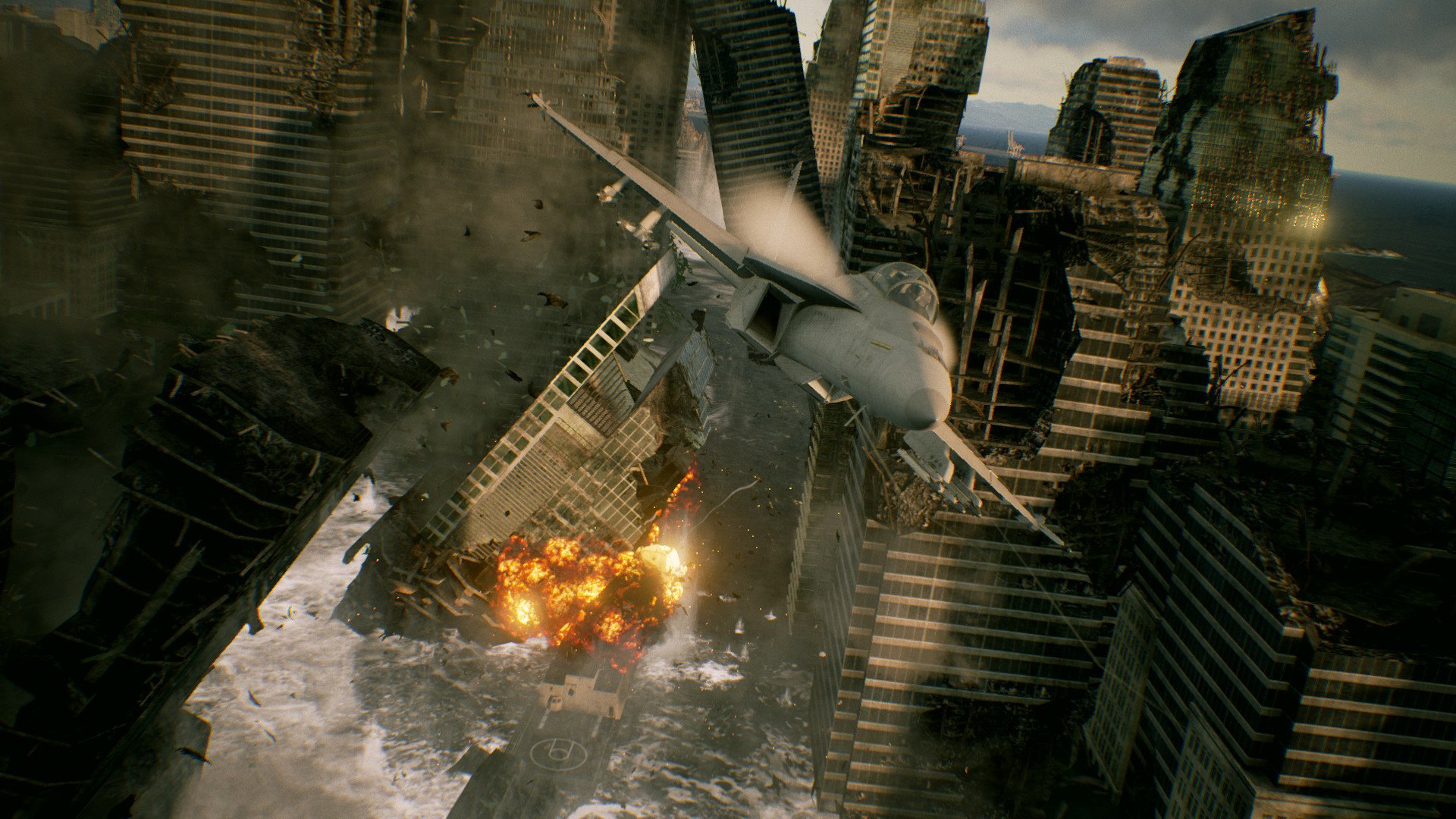 HD desktop wallpaper from the video game Ace Combat 7: Skies Unknown, featuring a fighter jet flying through a cityscape with skyscrapers and explosions in the background.