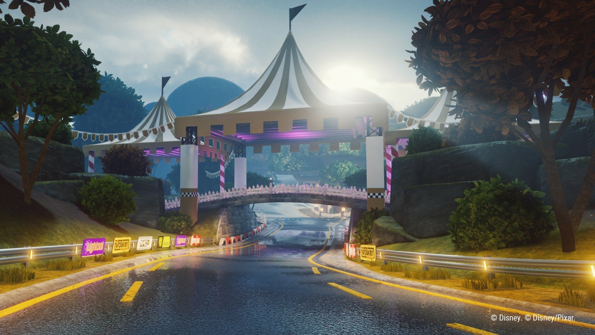 HD desktop wallpaper featuring a vibrant race track from the video game Disney Speedstorm, showcasing a scenic road with a circus tent bridge and lush greenery.
