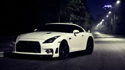 HD wallpaper of a white Nissan GT-R R35 parked on a dimly lit street at night.